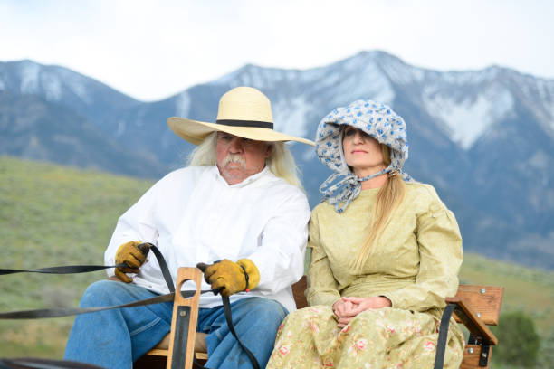 elderly couple dressed in cowboy style, sitting on the couch, looking at each other. Stylish Seniors