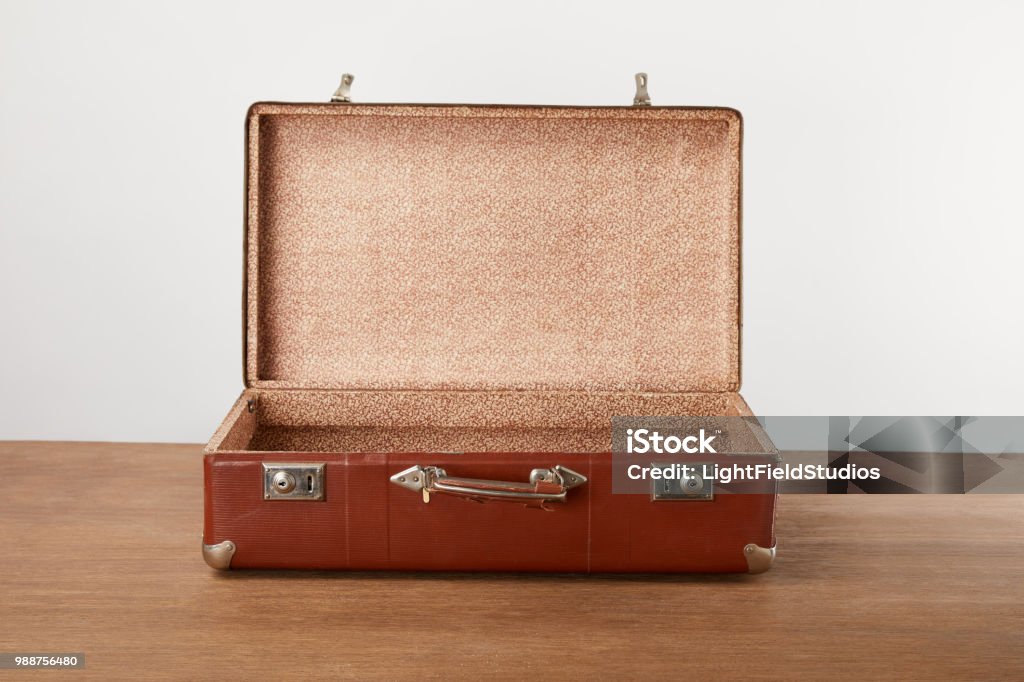 Open vintage suitcase on wooden table Suitcase Stock Photo