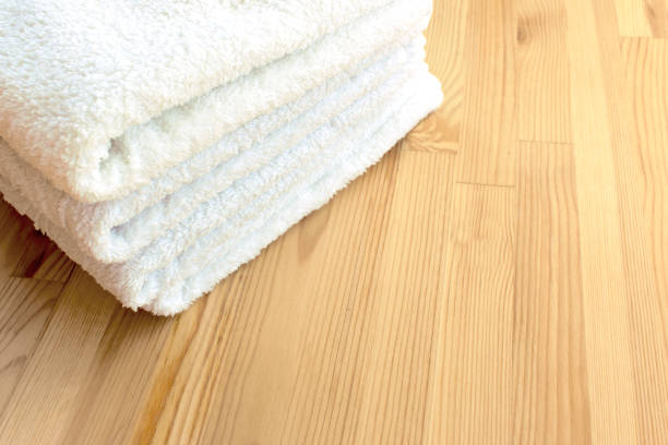 istock White towels on a light wooden background 988798000