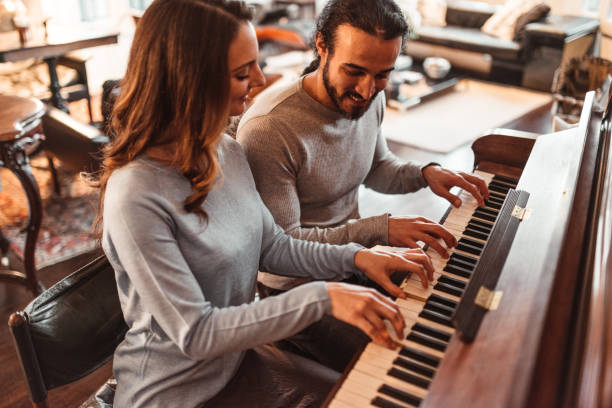 pareja tocando el piano en un apartamento de lux - pianist grand piano piano playing fotografías e imágenes de stock