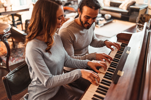 couple playing piano in a lux apartment