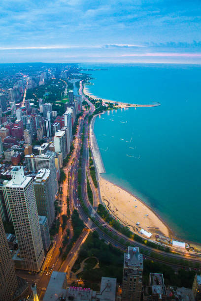 Chicago and Lake Michigan View of Chicago Illinois and Lake Michigan with beaches, buildings and roads in view at sunset lake shore drive chicago stock pictures, royalty-free photos & images