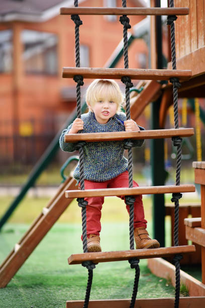istock Cute little boy having fun on outdoor playground 988882614