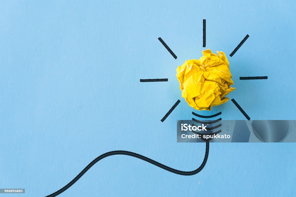 Ispirazione e concetto di grande idea. lampadina con carta gialla accartocciata su sfondo blu. - Foto stock royalty-free di Ispirazione