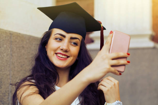 istock Happy graduate girl taking a selfie 988933810