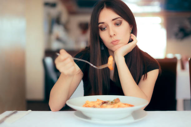 Female Customer Unhappy with the Dish Course in Restaurant Depressed lonely woman suffering from appetite loss hungry stock pictures, royalty-free photos & images