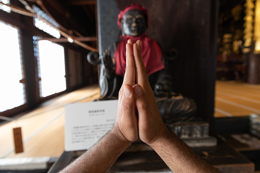 Asian man praying at temple