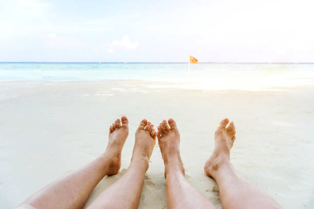 istock Couple relaxing in summer holiday on beach 989051384