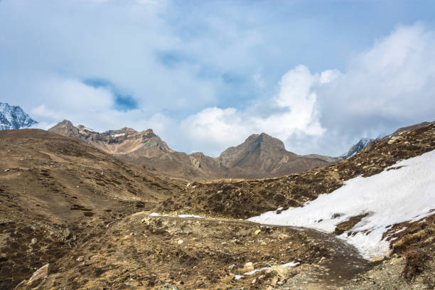 istock Mountain landscape with snow on the trail and white clouds, Nepal. 989075230