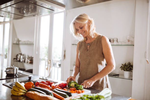 istock senior woman chopping vegetables on the kitchen counter 989095340