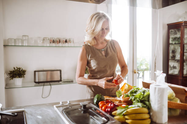 istock senior woman chopping vegetables on the kitchen counter 989095452