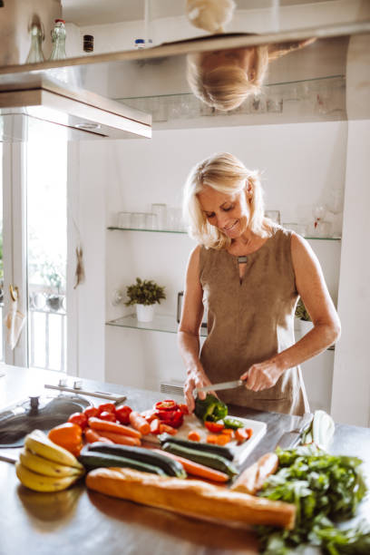 senior woman chopping vegetables on the kitchen counter