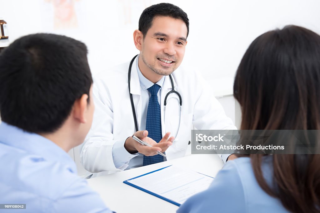 Couple patients consulting with Asian male medical doctor in hospital room Couple patients consulting with handsome Asian male medical doctor in hospital room Doctor Stock Photo