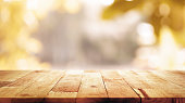 Wood table top on blur abstract natural foliage bokeh background, vintage tone