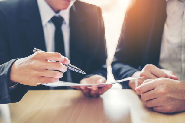 Business people Meeting negotiating a contract between two colleagues Business people Meeting negotiating a contract between two colleagues endorsing stock pictures, royalty-free photos & images