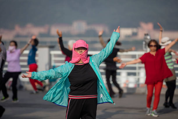 Woman are practice square dance in the morning. Some of them covered the face to prevent sunburn.