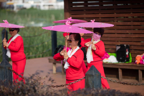 Woman are practice square dance in the morning. Some of them covered the face to prevent sunburn. It is a popular way to replace gym exercise at China.