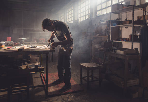 istock Young repairman working with sander in a carpentry workshop. 989170674