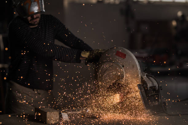 istock Metal worker cutting iron while working with electric saw in a workshop. 989170802