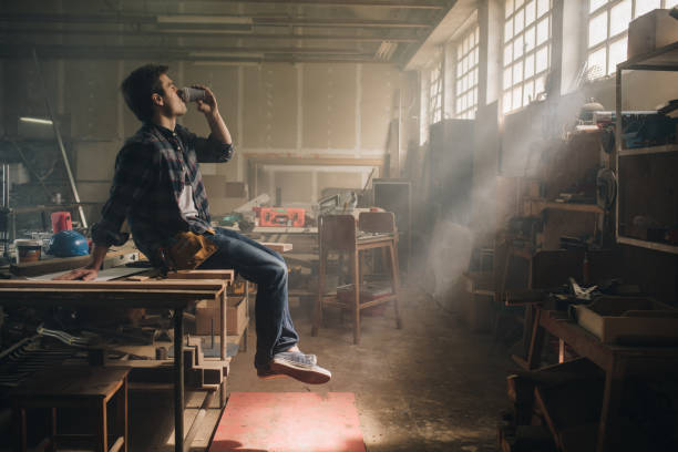 istock Young carpenter enjoying in coffee during his break in a workshop. 989178994