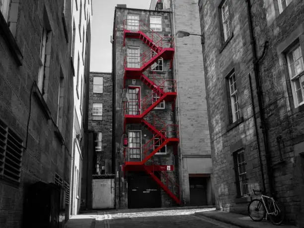 Red fire escape in Scottish alley.