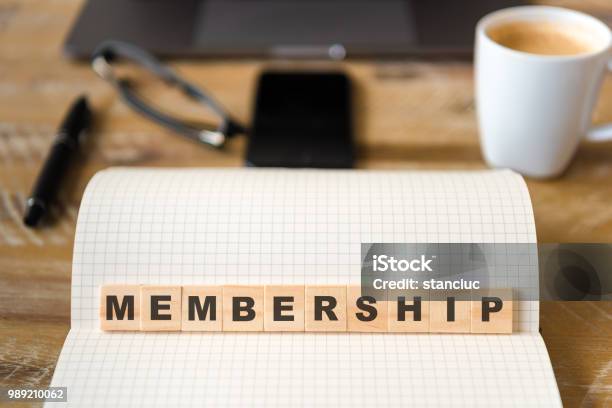 Closeup On Notebook Over Wood Table Background Focus On Wooden Blocks With Letters Making Membership Text Stock Photo - Download Image Now