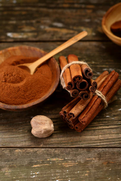 istock Cinnamon spice on wood, food closeup 989214144