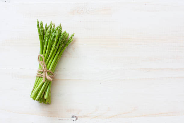 fresh asparagus on white wood background - green asparagus imagens e fotografias de stock