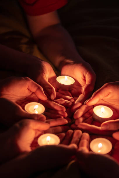 istock prayer with candles in hands 989222858