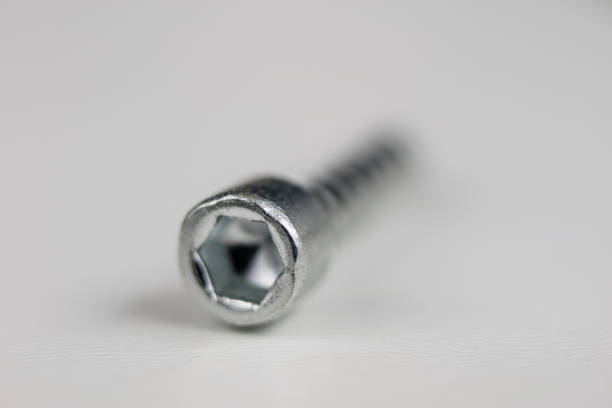 Screws on a white table. Accessories for screw connections. Light background.