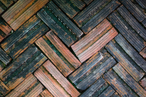istock Old brick paving on a sidewalk, ancient old red brick grunge floor fragment background. 989233464