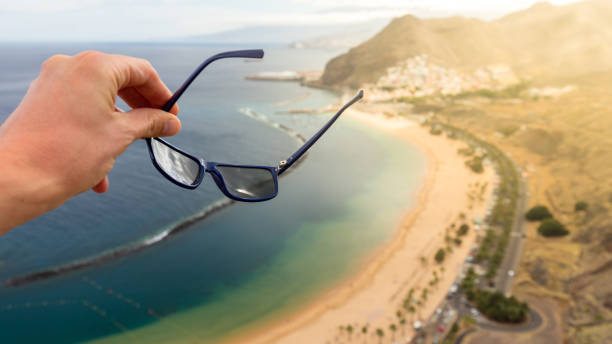 ręka utrzymuje okulary z plaży teresitas na rozmytym tle. - keeping above water zdjęcia i obrazy z banku zdjęć