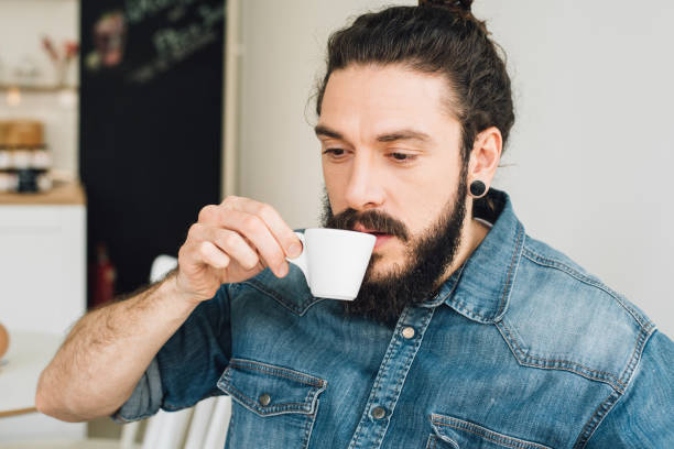 istock Young man in a coffee shop drinking coffee 989275946