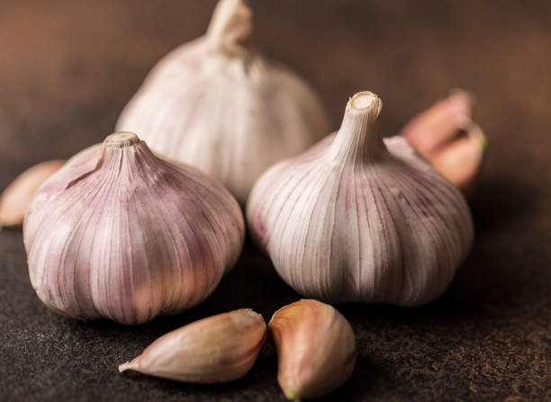 istock Fresh garlic on wooden background. Garlic bulbs 989283536