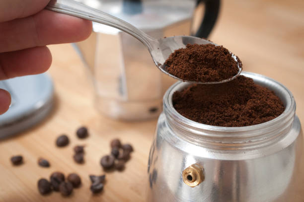 istock Hand put fresh ground coffee into a moka pot 989287444