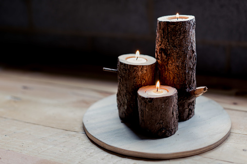 three candle holders made from wooden logs