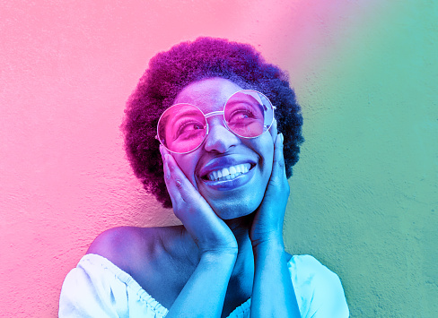 Millennial african woman smiling and wearing sunglasses - Black afro girl having fun in front of camera - Focus on face - Youth lifestyle concept - Radial blue and purple filter editing