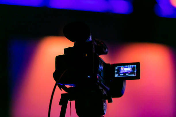 TV Camera on a live film set Silhouette of a TV Camera filming a live broadcast microphone stand photos stock pictures, royalty-free photos & images