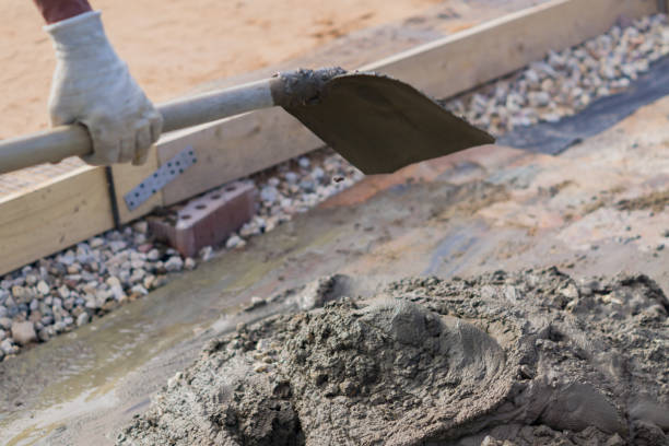istock worker mixing concrete and gravel  with spade on construction cite 989343998