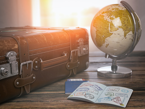 Concepto de viaje o turismo.  Antigua maleta abierta pasaporte con sellos de visa y globo. photo