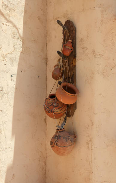 istock Terra cotta pots hanging on an adobe wall 989348200