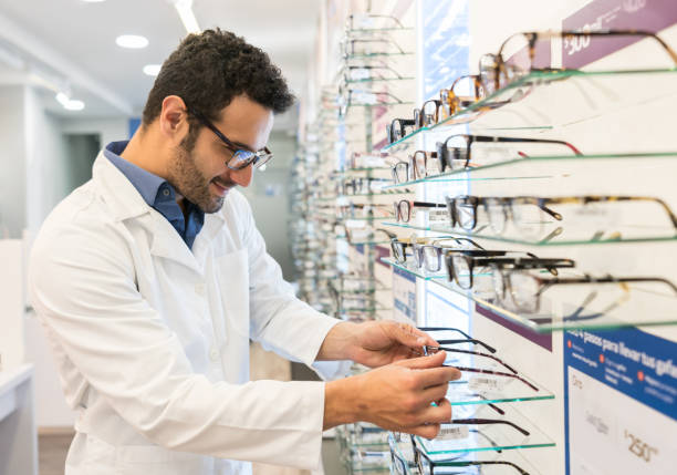 istock Optician holding glasses at the optical shop 989349014
