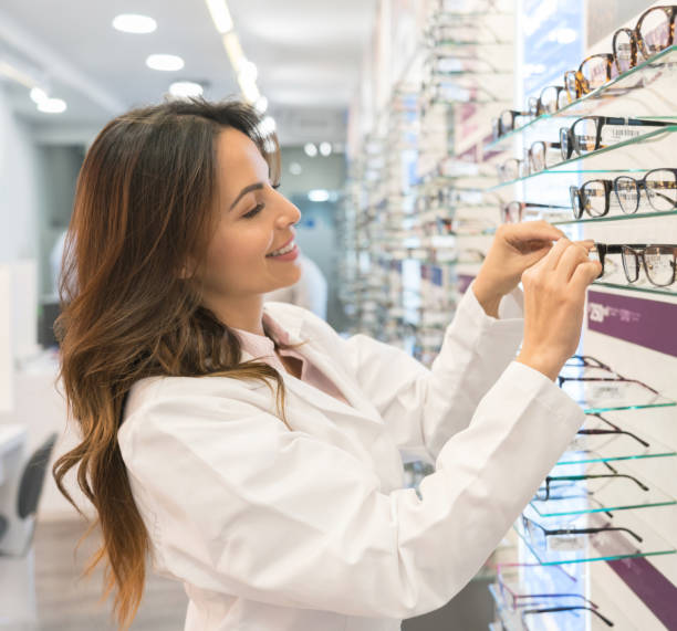istock Optician holding glasses at the optical shop 989349054