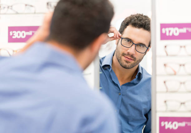 istock Handsome man trying glasses at the optical shop 989349352