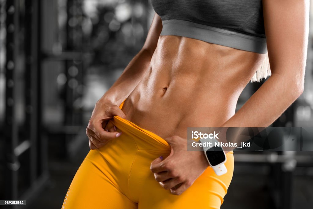 Fitness woman showing abs and flat belly. Beautiful muscular girl, shaped abdominal Abdomen Stock Photo