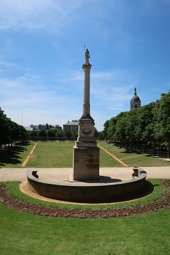Rennes, France – June 27, 2018: photography showing a public park called Parc du Thabor in French and Notre-Dame-en-Saint-Melaine church. The photography was taken from the street of the city of Rennes, France.