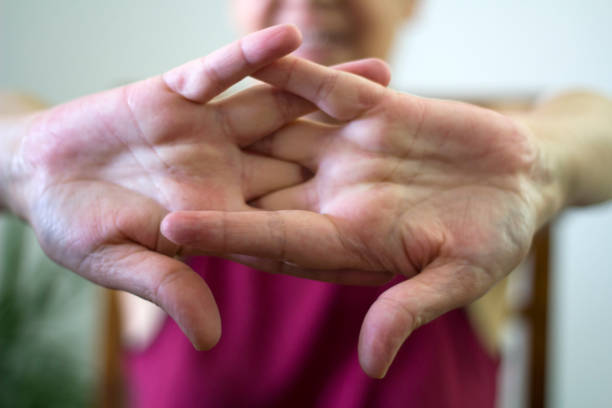 older woman cracking their knuckles - knuckle imagens e fotografias de stock