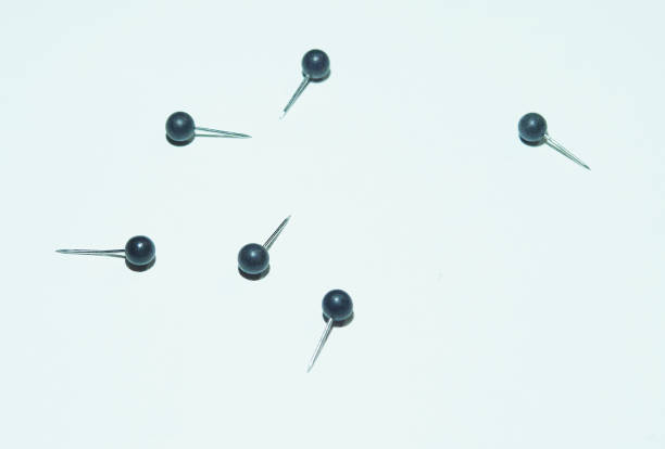 istock Group of rounded black-headed push-pins on white background 989395536