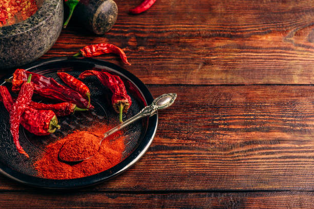 istock Ground and dried chili peppers on metal plate 989403294