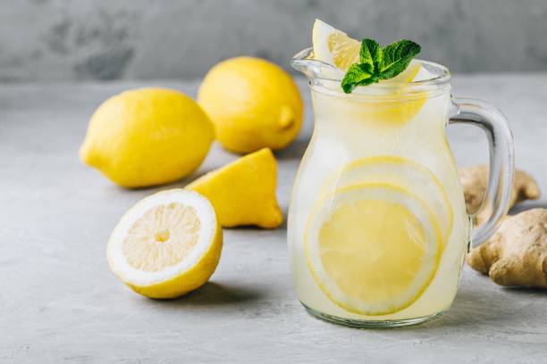 boire de la limonade maison d’été rafraîchissante avec tranches de citron, le gingembre et glace - waterlemon photos et images de collection